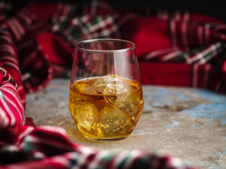 Still-life with a glass of bourbon. A glass of whiskey with ice. Concept of autumn spleen
