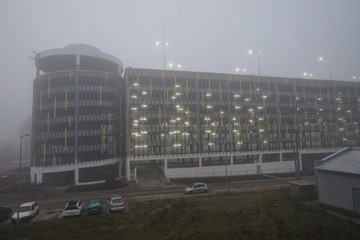 seven-level parking in the fog in the early morning, and burning lanternsМ