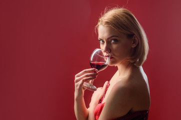 Attractive woman drinking red wine. Stylish woman in restaurant celebrate new year or Christmas. Holidays celebration concept. Copy space for advertise.