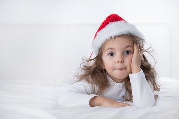 Christmas time, little girl in Santa Claus hat smilling