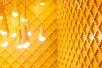 Designed yellow lamps on wooden background. White lights in the room