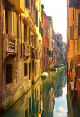 Beautiful narrow canal with silky water in Venice
