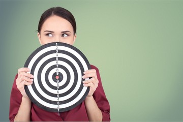 Beautiful businesswoman portrait holding round target of darts