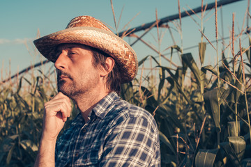 Portrait of serious farm worker in corn field