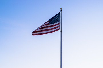 Majestic United States flag with blue sky background