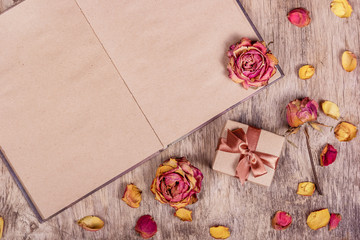 Dried roses and an open book. Paper background. Romantic background. Gift box. Copy space