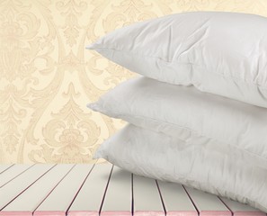 White Pillows Pile on wooden background