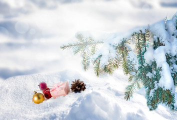 Christmas composition, gift boxes, fir branches, ball, small red apples. Christmas toys on a snow.