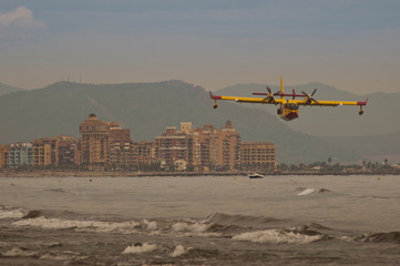 Firefighting aircraft flying over the sea on the beach