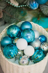 Turquoise, blue and white Christmas balls in a white basket