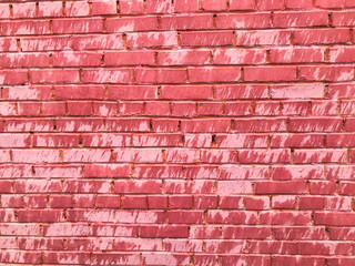 Texture of a beautiful unique unusual pink tender old cracked brick wall of rectangular bricks with seams painted with pink old shabby paint. The background