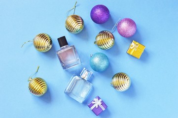 Flat lay Christmas decoration and gifts. Gold, purple balls and perfume bottles