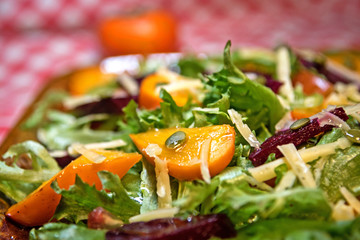 Healthy salad with lettuce salad, persimmon and beets. Persimmon salad. Diet. Vegetarian food.