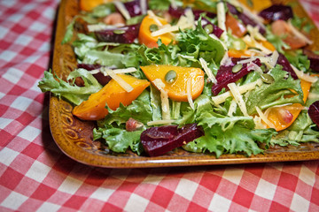 Healthy salad with lettuce salad, persimmon and beets. Persimmon salad. Diet. Vegetarian food.