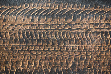 Traces of car tires on dry sand. Patterns in the sand