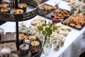 garden receptions - table with a white tablecloth, with various kinds of sweets, cakes and snacks