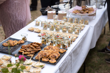 garden receptions - table with a white tablecloth, with various kinds of sweets, cakes and snacks