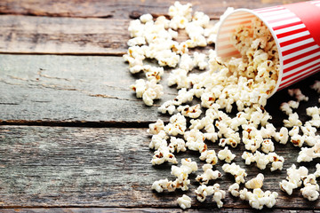Popcorn in striped bucket on wooden table