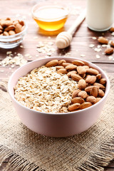 Oatmeal with almonds in bowl on wooden table