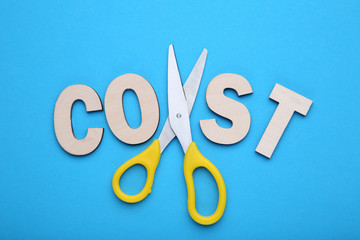 Word Cost and scissors on blue background