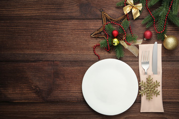 Kitchen cutlery with plate and christmas decorations on wooden table