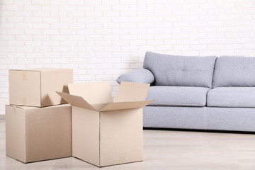 Cardboard boxes with grey sofa on brick wall background