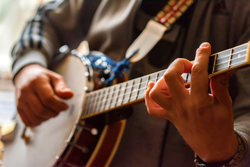 Close up hands of man playing 8-string mandolin