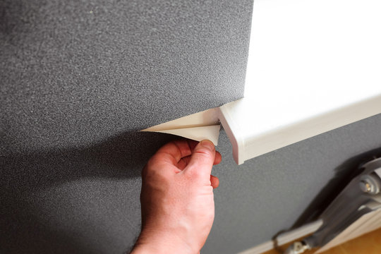 Gray wallpapering near bright window openings in apartment. Renovation in home.