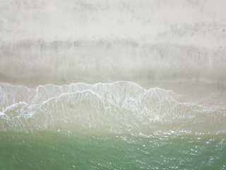 Fototapeta na wymiar Aerial view of waves on the sandy beach