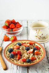 Healthy Homemade Oatmeal with Berries - fresh strwberries and blueberries, for Breakfast. Rustic white wooden table.