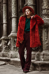 Outdoor full body fashion portrait of young beautiful woman wearing trendy oversized orange faux...