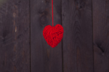 Two heart made of red wool yarn on wood background.Valentine's day concept.