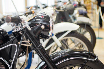 Row of many motorcycle for sale. Motorcycles standing in the row at a store, closeup. Motobikes in a row