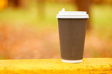 Coffee espresso on wood table nature background in park , warm tone. Disposable coffee cup on...