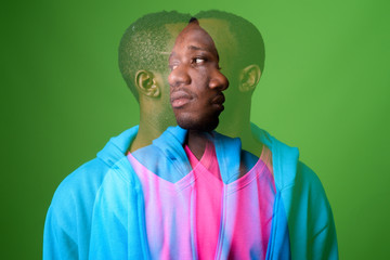 Double exposure shot of young African man against green background