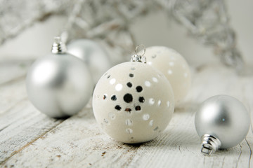 Christmas white background with silver decorative balls or baubles on rustic wooden background.