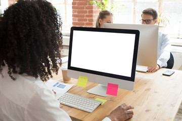 African American worker using computer at workplace, looking at white screen mock up, female...