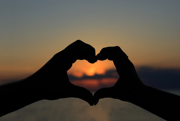 
Two lovers (girl and boyfriend) hold hands at the sunset sunsets on the beach of the ocean. Love, romance, family, caring. 