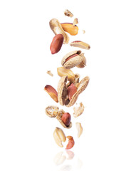 Cracked peanuts fall down isolated on white background