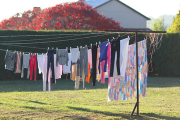 Colorful underwear hung on ropes and dried in the wind in the yard of the house among the greenery....