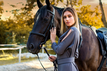 Obraz premium Young beautiful woman with a horse