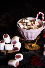 Good New Year spirit. Coffee with marshmallows and cinnamon. Candy canes. Pink mug. Cooking yourself. Home comfort. New Year. Christmas time. Winter mood.