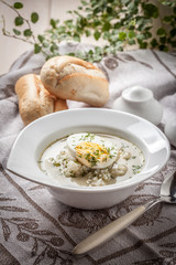 Sorrel soup with egg in white bowl.