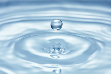 Fototapeta na wymiar pure blue water surface with droplet splash