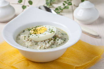 Sorrel soup with egg in white bowl.