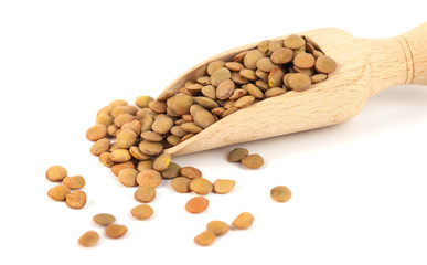 dry lentils on wooden spoon isolated on a white background