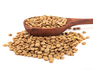 dry lentils on wooden spoon isolated on a white background