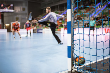 Detail of handball goal post with net and ball carrying to the goal - obrazy, fototapety, plakaty