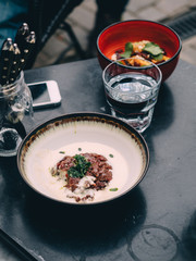 Meat tartar on wooden table in cafe street