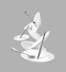 White kitchenware with forks and knives isolated on gray background